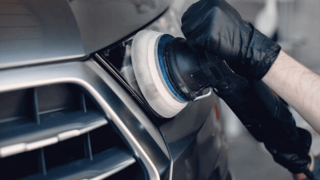 A polisher is used on a car.