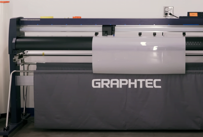A plotter machine prints out paint protection film to be used on a car.